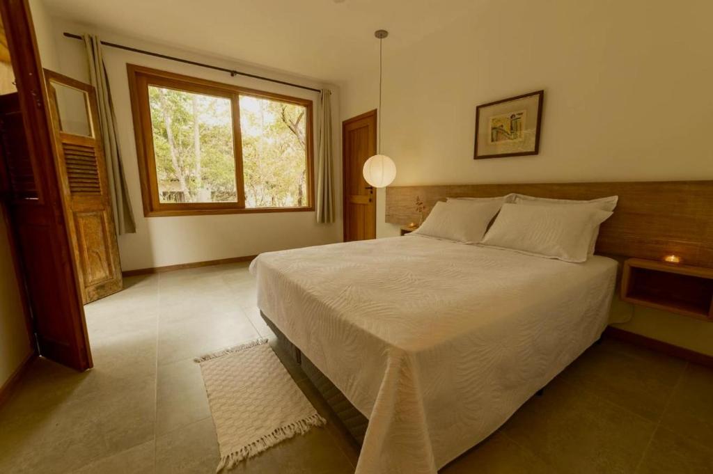 a bedroom with a large bed and a window at Estalagem Angu Duro in São Gonçalo do Rio das Pedras