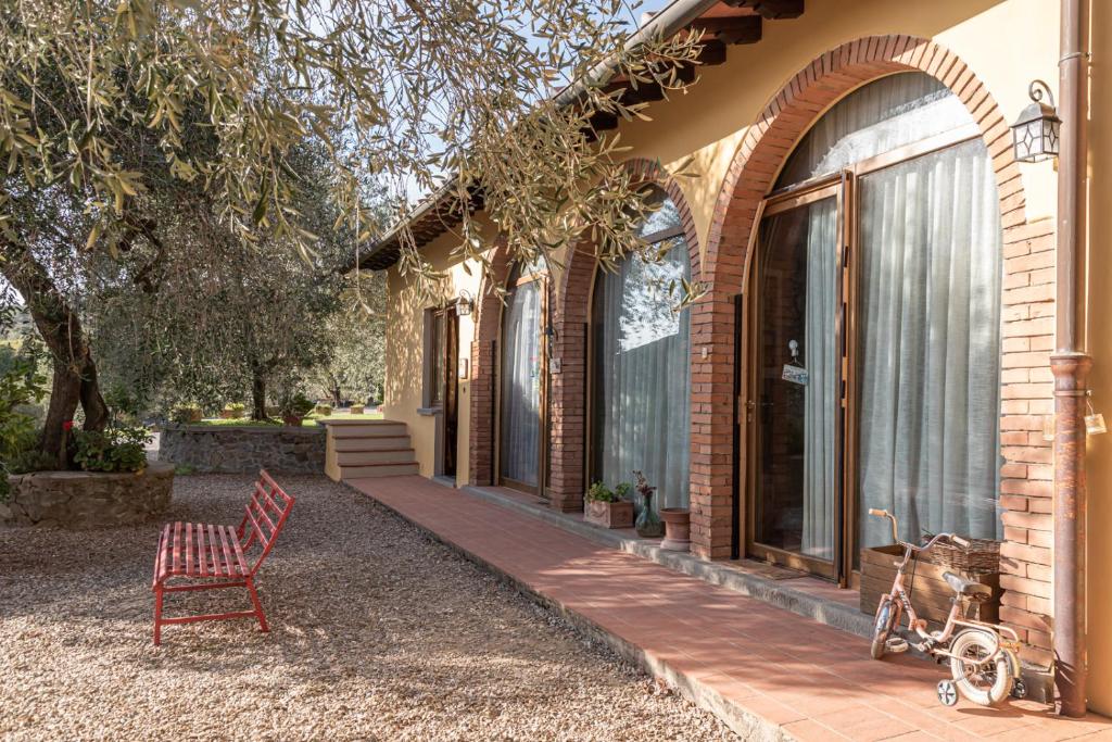 a red chair sitting outside of a house at Il Pintello - Lo Scricciolo in Massanera