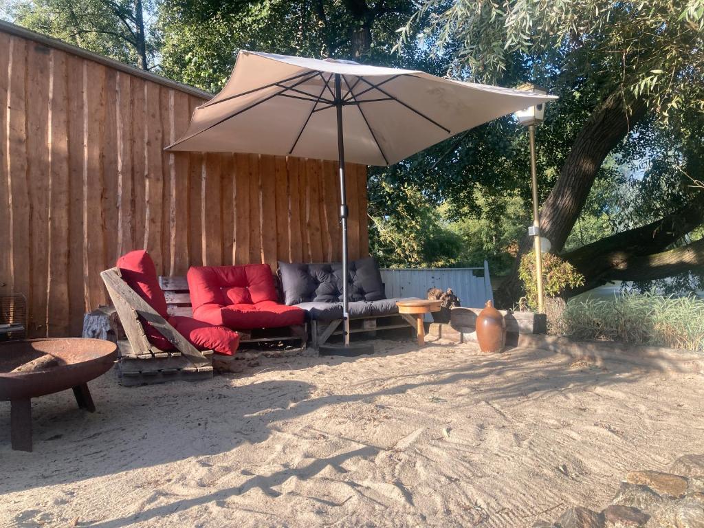 a patio with a couch and an umbrella at Ferienwohnung Seeblick in Bad Bodenteich