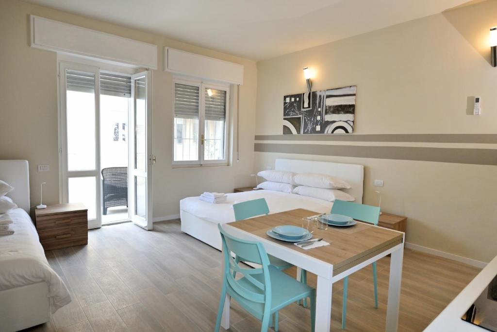 a bedroom with a bed and a table with chairs at City Loft in Piacenza