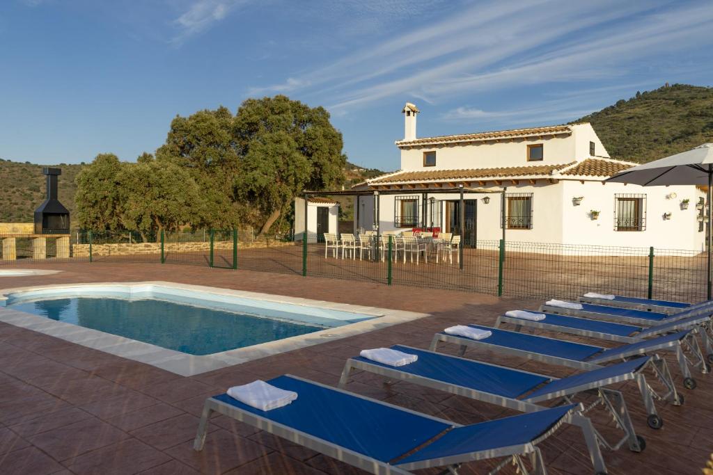 eine Villa mit einem Pool und Liegestühlen in der Unterkunft Casa Rural Mis Niñas in Casabermeja