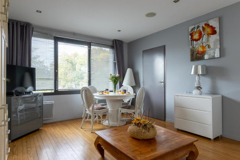 a living room with a table and chairs and a tv at Lumineux - parking - wifi - clim - 3 lits dont 1 King size - jardin- in Mont-de-Marsan