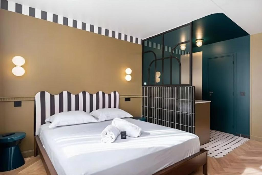 a bedroom with a large bed with white sheets at Studio Élégant-Une Escapade Raffinée en Plein Cœur de la Ville in Lyon