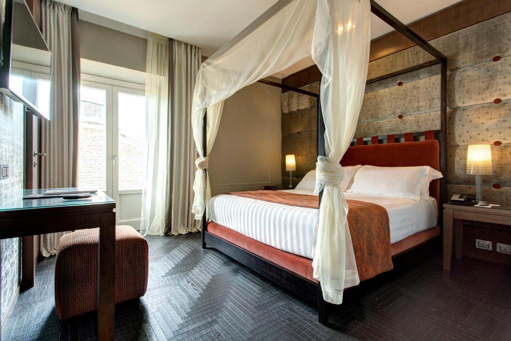 Säng eller sängar i ett rum på Mascagni Luxury Rooms & Suites