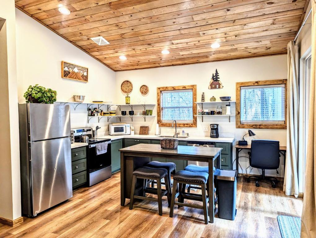 eine Küche mit Tisch und Kühlschrank in der Unterkunft Relax & Recharge in Cozy Pinetop 2BR Retreat in Pinetop-Lakeside