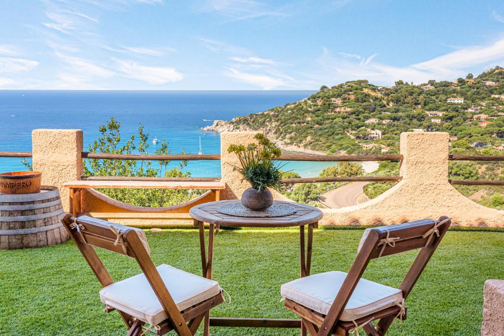 eine Terrasse mit Tisch und Stühlen und dem Meer in der Unterkunft Sardinia Villa Torre delle Stelle in Torre delle Stelle