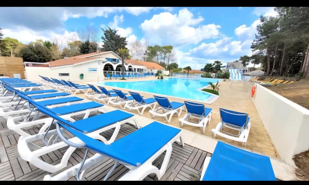 - un groupe de chaises longues bleues et blanches à côté de la piscine dans l'établissement mobil-home family 6 personnes, 3 chambres Camping 4 étoiles bois dormant, à Saint-Jean-de-Monts