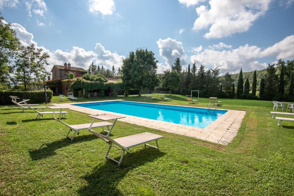 - une piscine dans une cour avec 2 chaises longues dans l'établissement Agriturismo Il Chiassale, à Rapolano Terme