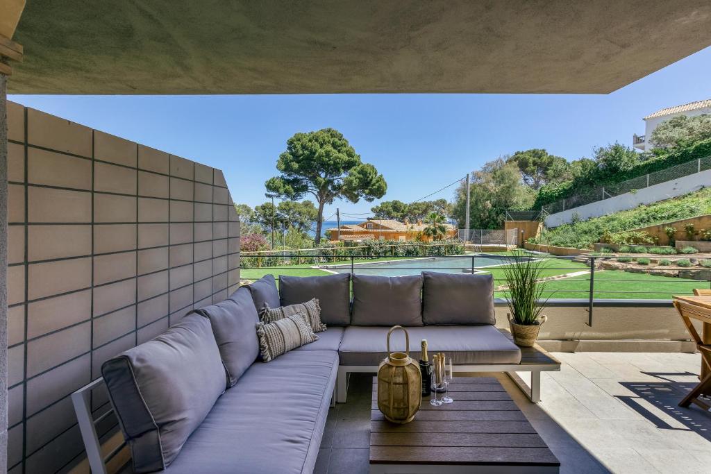 a couch on a patio with a view of a tennis court at Bonavista Begur in Begur