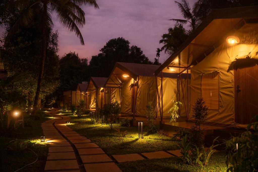 a row of tents at night with lights at Vanantara - Riverside Eco Retreat in Ernakulam
