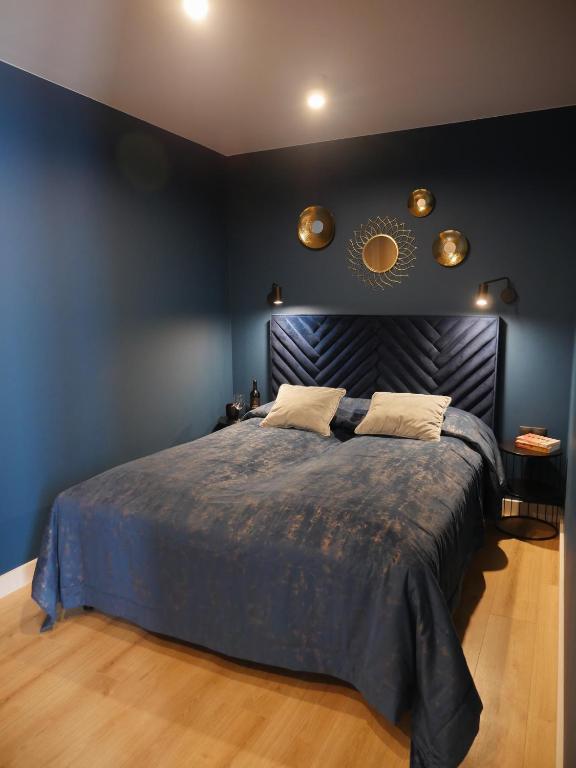 a bedroom with a large bed with a blue wall at Home & Travel Apartamenty w centrum Łodzi - Piotrkowska - Klimatyzacja - Manufaktura - OFF Piotrkowska - EC1 - ATLAS Arena - Orientarium - Monopolis in Łódź