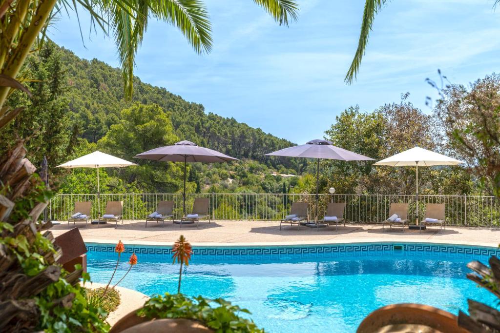 a swimming pool with chairs and umbrellas at Finca Especial El Pino en Esporles in Esporles