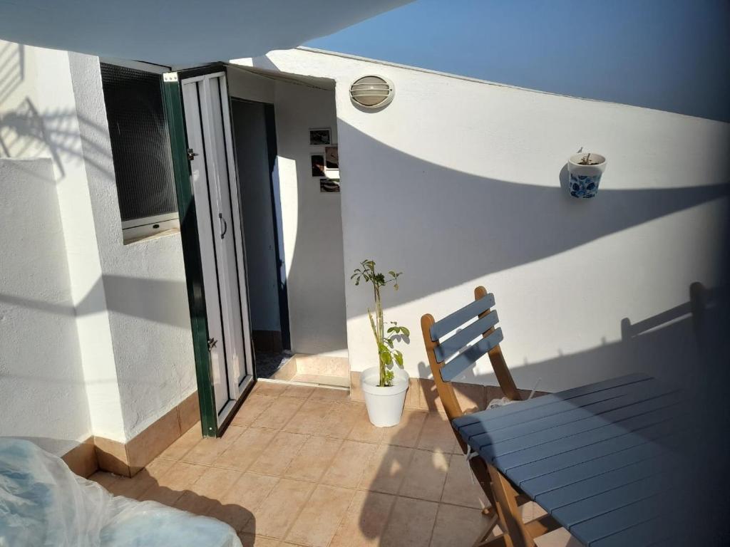 a blue bench sitting on a porch with a plant at A Beautiful Townhouse with a roof top terrace in Rute