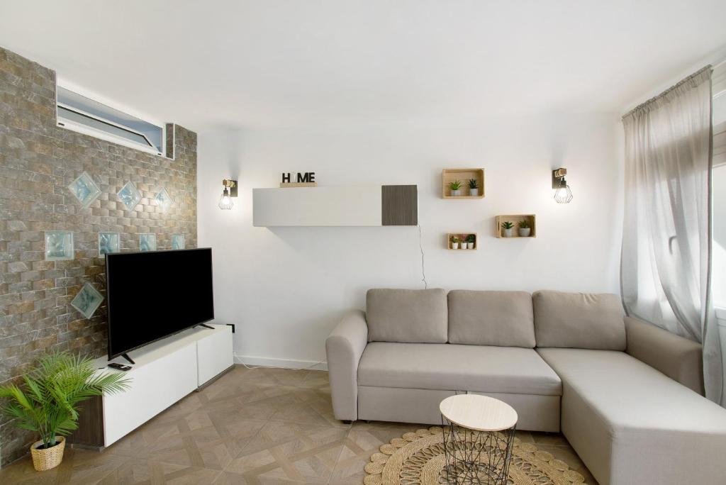 ein Wohnzimmer mit Sofa und Fernseher in der Unterkunft Apartamento La Burrita in San Agustín