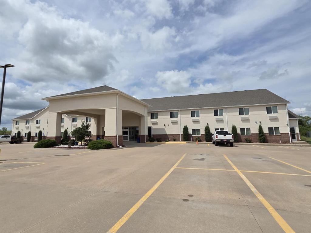 a large white building with a parking lot at SureStay Studio By Best Western El Dorado in El Dorado
