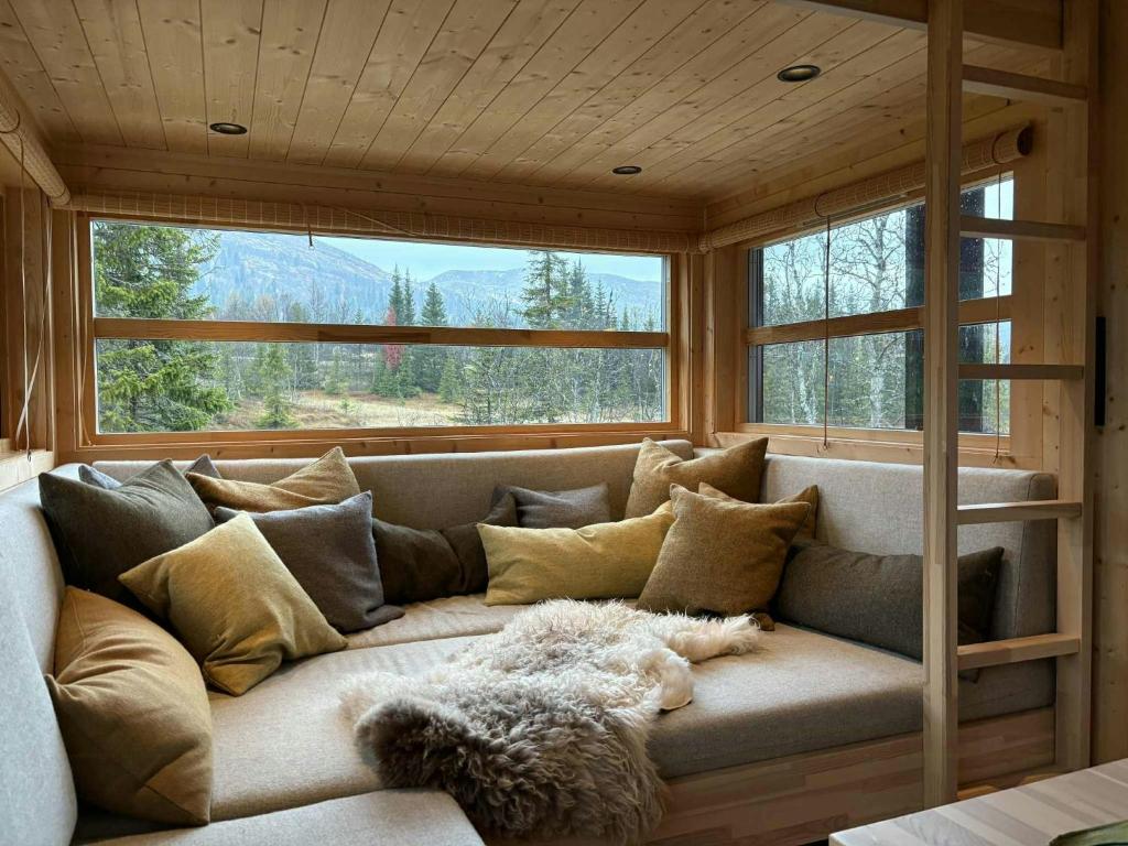 a large couch in a room with windows at Ål Cabin With Views Of Marshland And Mountains in Haglebu