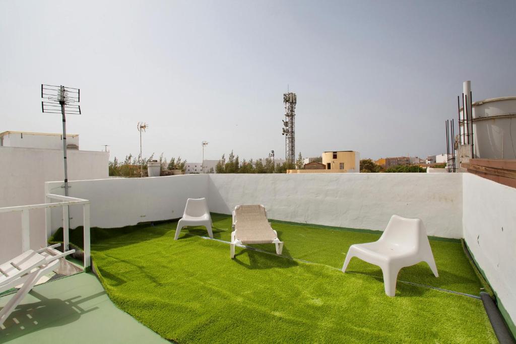 two chairs on a roof with green grass at Atico vecindario, aeropuerto in Cruce de Arinaga