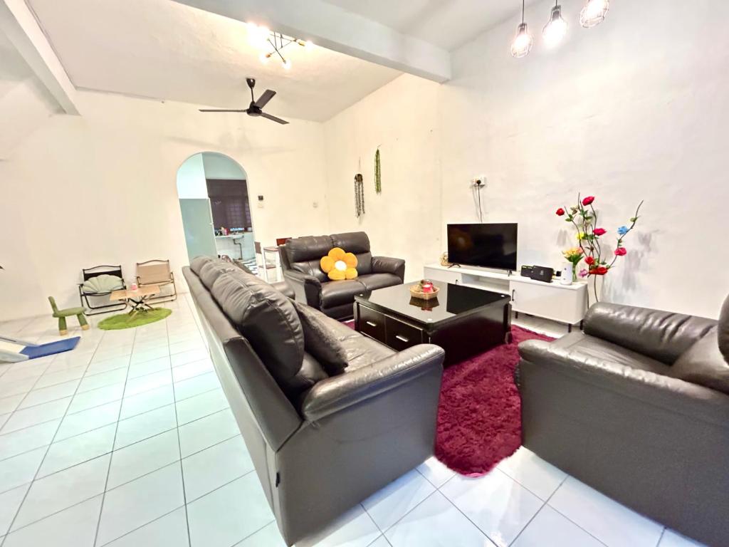 een woonkamer met 2 leren banken en een tv bij Cozy 10 Entire House 4 Bedroom At Alma Bukit Mertajam in Bukit Mertajam