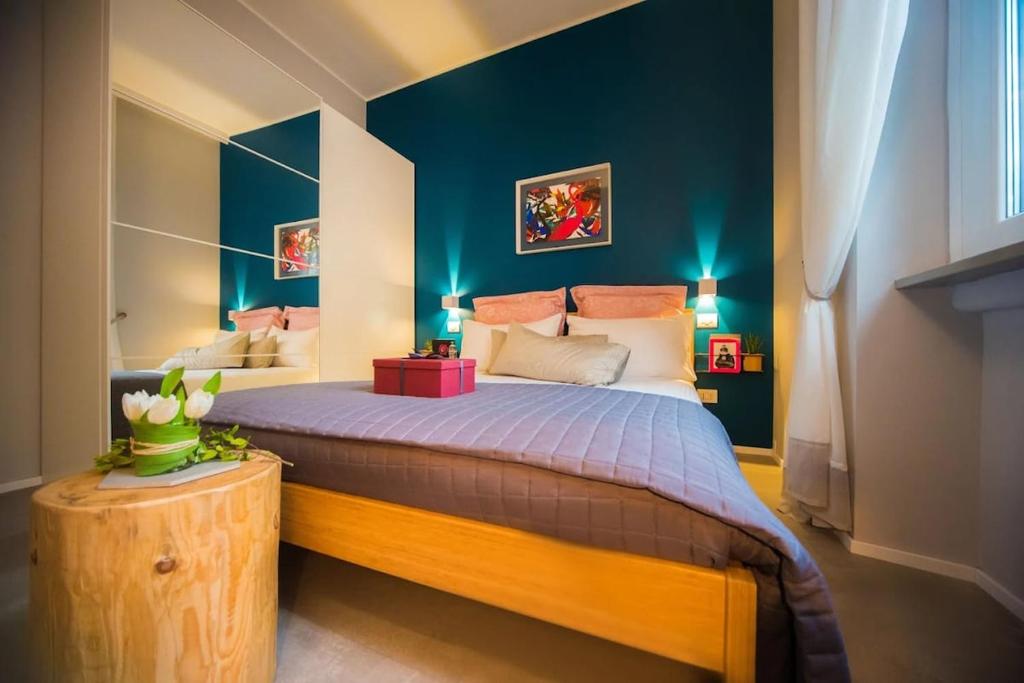 a bedroom with a large bed with blue walls at Luxury Boutique Apartment Milan in Milan