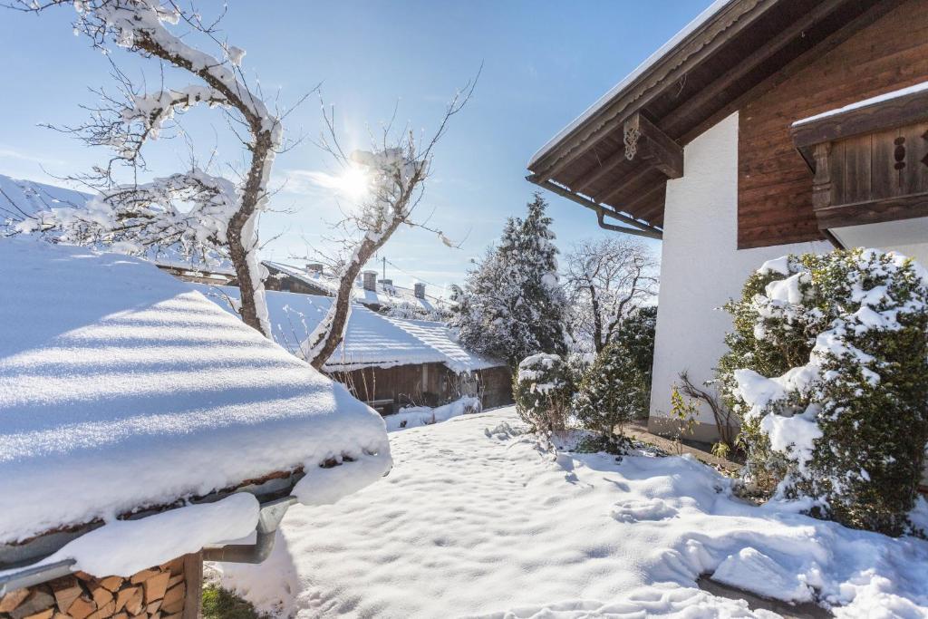 a snow covered yard next to a house at Apartment Bergblick in Frasdorf