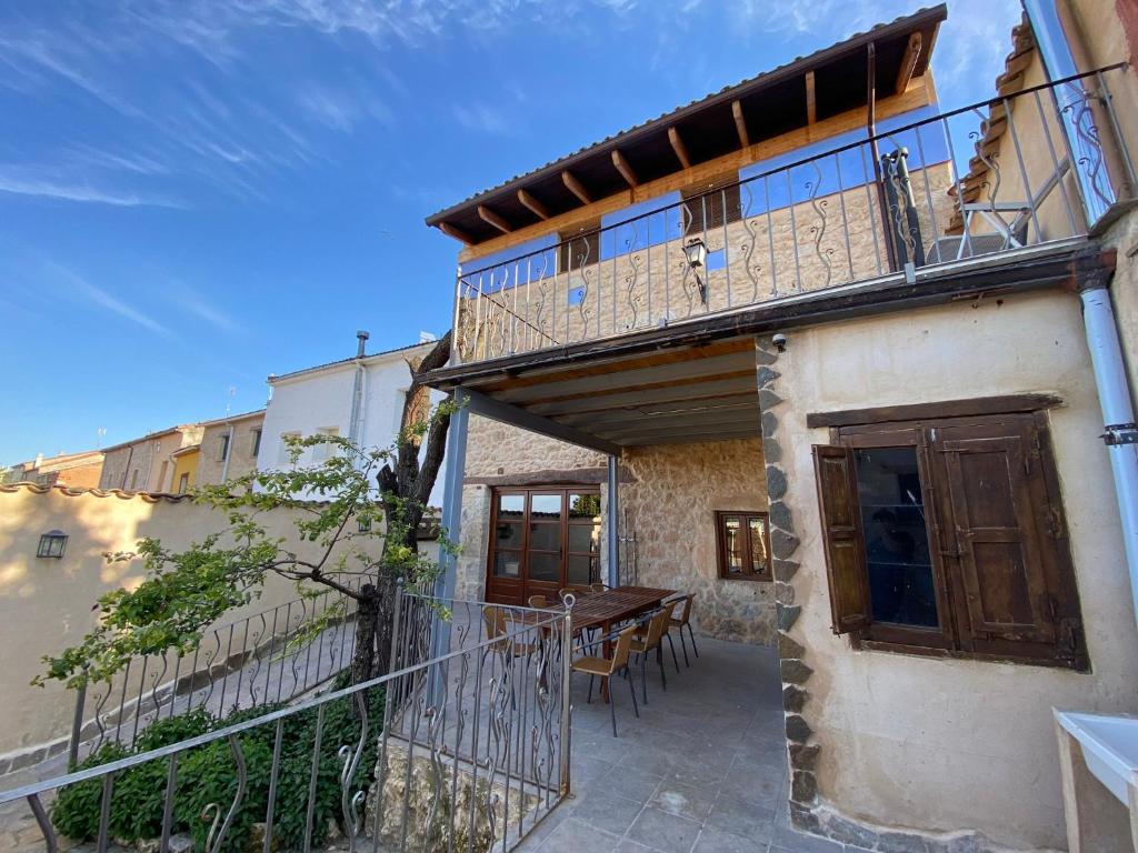 a house with a balcony and a table on the side at La Mambla de la Ribera in Mambrilla de Castrejón