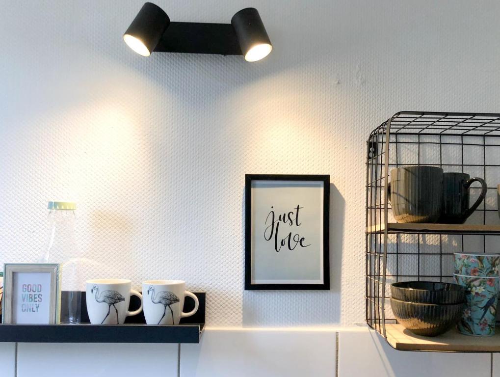 a shelf with two cups and a picture on a wall at Ruhiges Apartment Münster Baumberge in Nottuln