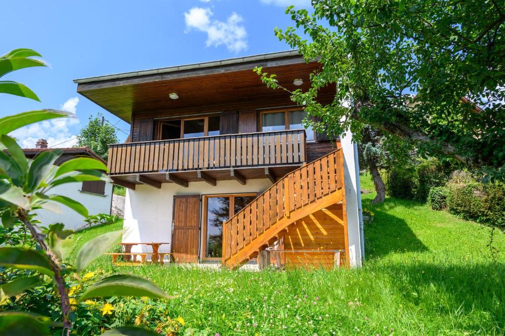 a house with a balcony and a deck at Chalet Sol La Mi in Soultzeren