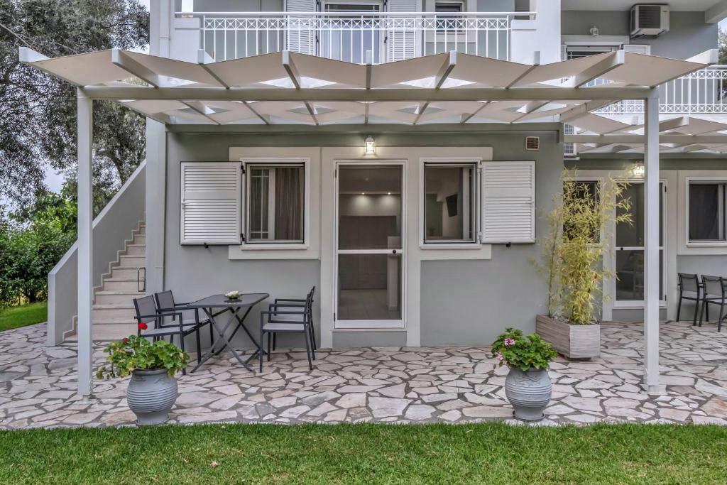 a patio with a table and chairs under an umbrella at Elaia studio 3 in Lefkada Town