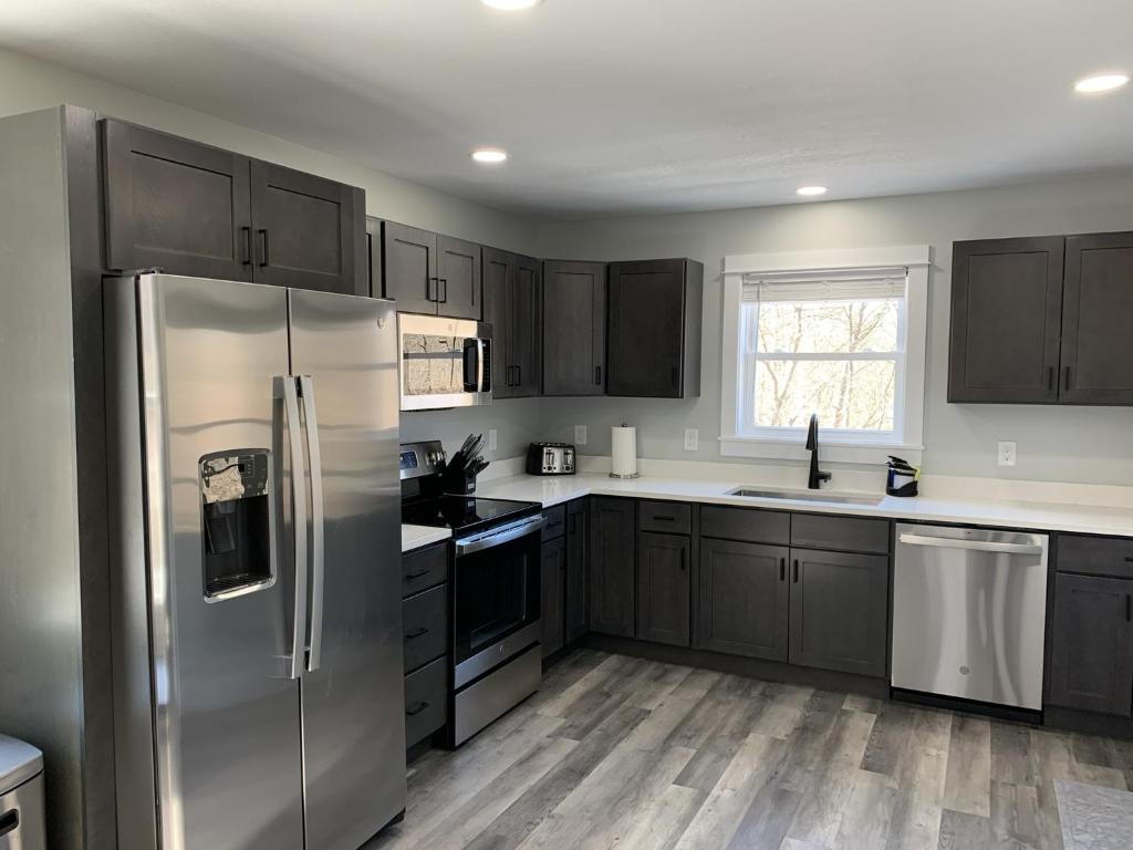 a kitchen with stainless steel appliances and wooden floors at The Fallviews at Burdett Falls in Burdett
