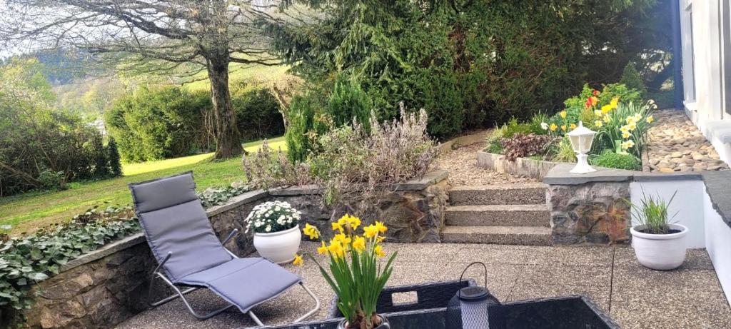 un patio avec une chaise et des plantes et des fleurs dans l'établissement O'Schwarzwald, à Münstertal