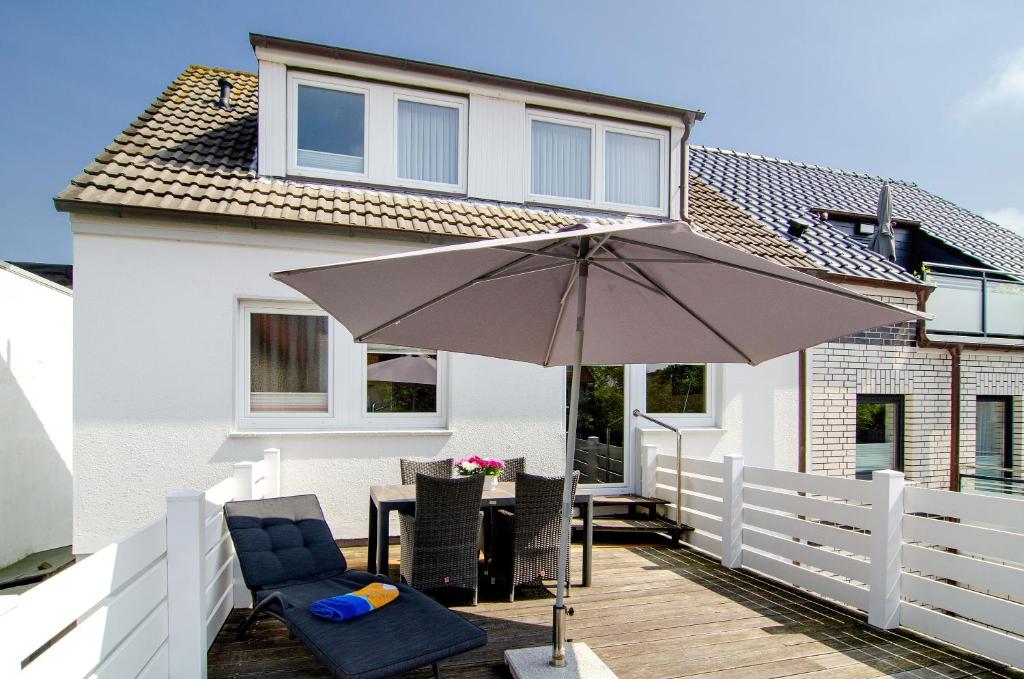 a patio with an umbrella and a table and chairs at Huus Nördernee 1 in Norderney