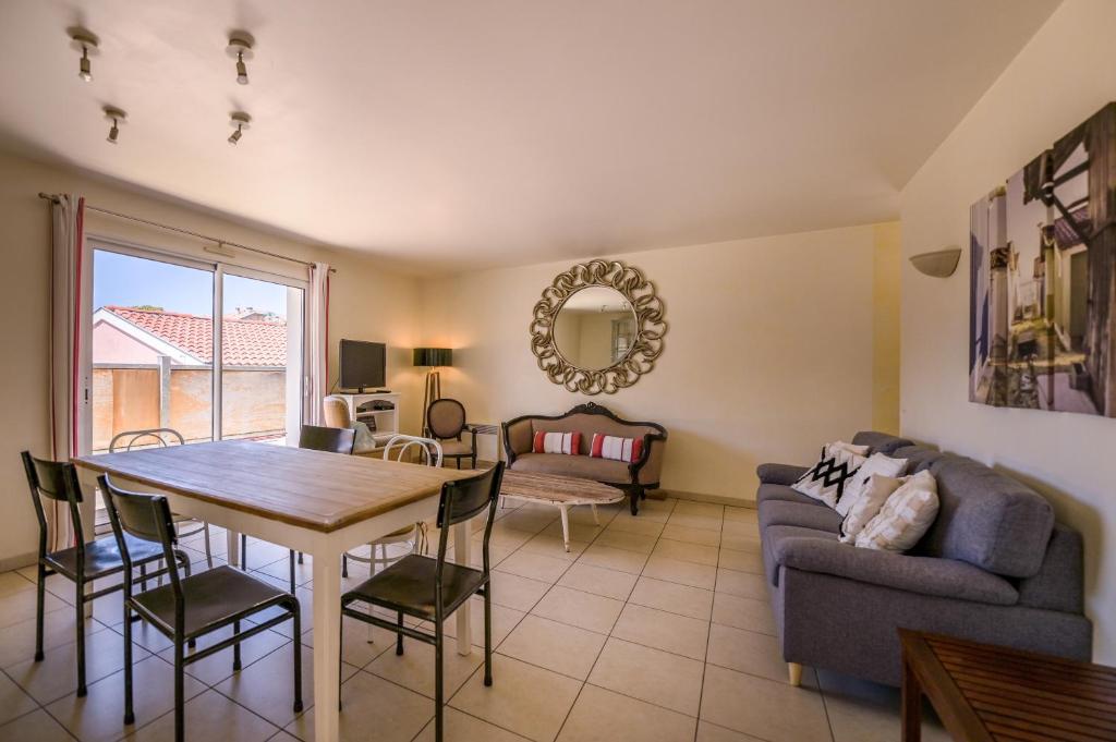 a living room with a table and a couch at Arcachon Balsamo plage 8 in Arcachon