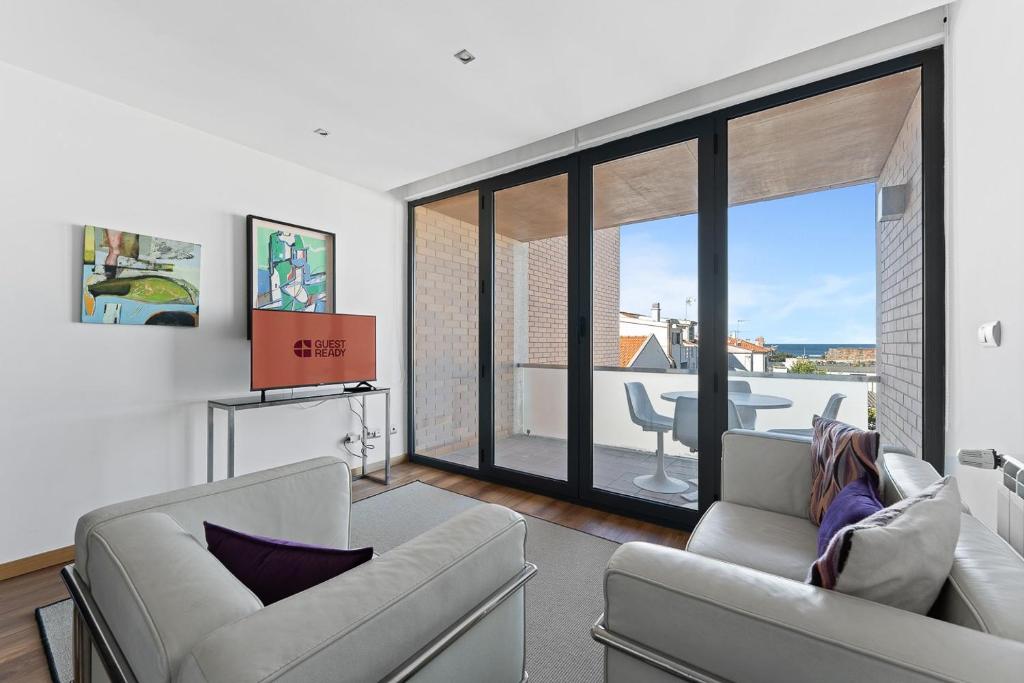 a woman sitting on a couch in a living room at GuestReady - Moledo's beach and sun in Santana