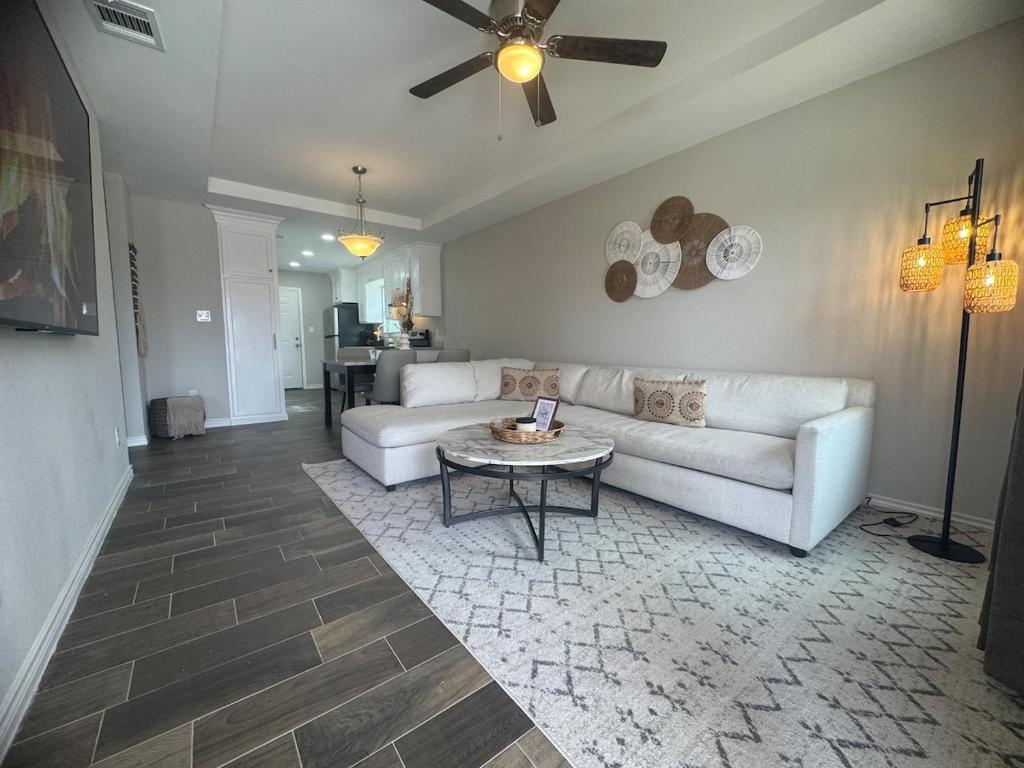 ein Wohnzimmer mit einer weißen Couch und einem Tisch in der Unterkunft Lucky Ace Suite - Next to Kickapoo Casino in Eagle Pass