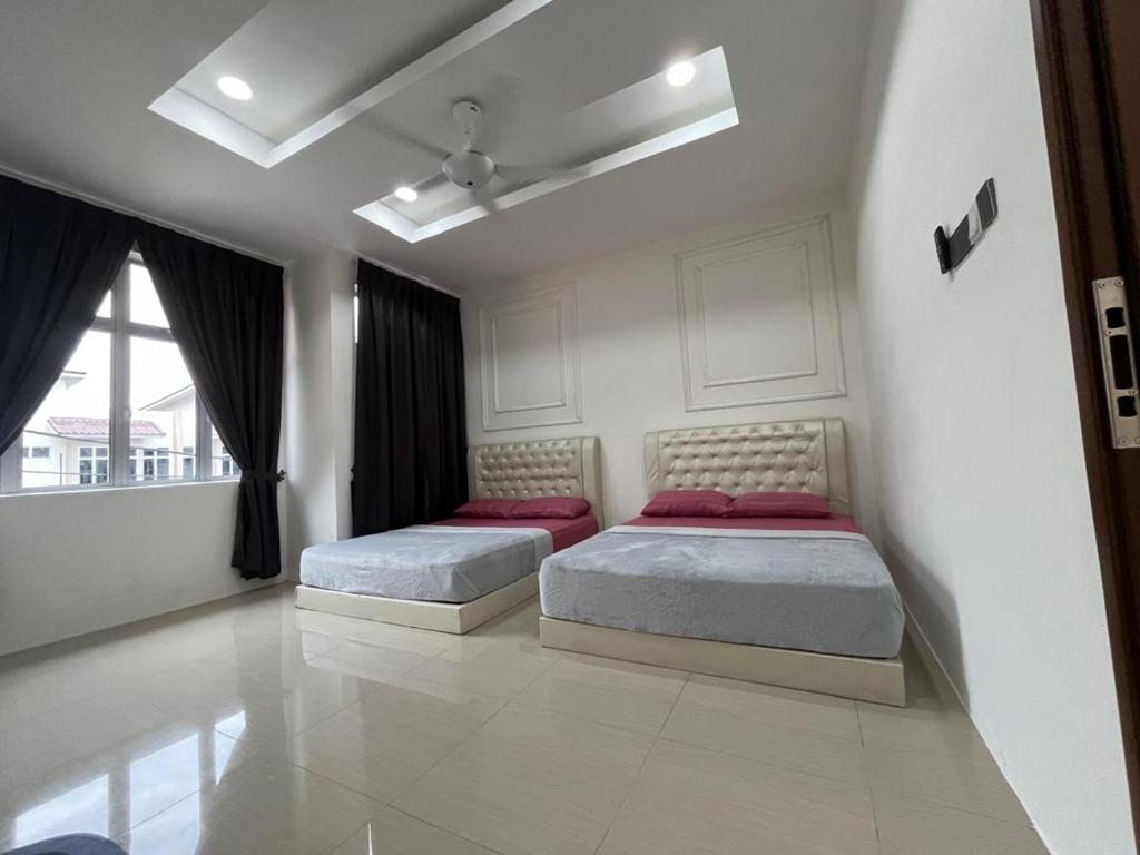 two beds in a white bedroom with a window at Homestay Kayangan Gua Musang 2 in Gua Musang