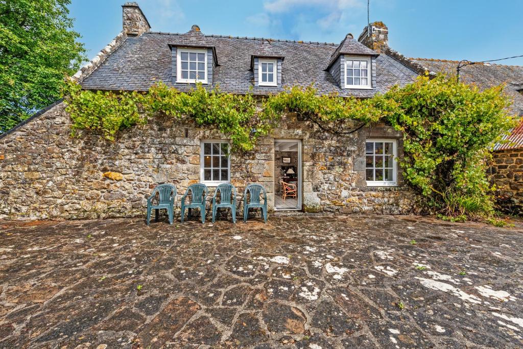 ein Steinhaus mit zwei Stühlen davor in der Unterkunft Penn ar Bed 5kms des plages in Crozon