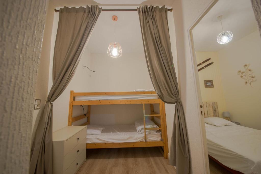 een slaapkamer met een stapelbed en een spiegel bij Le 14 De Pic in Cauterets