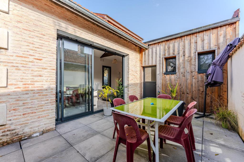 a patio with a green table and chairs at Villa 5 étoiles in Arcachon