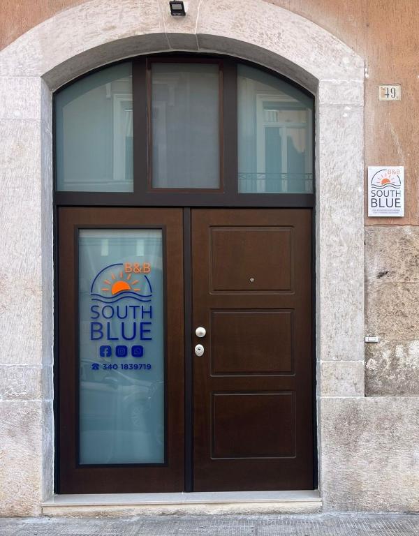 a brown door with a sign on it at South Blue Apartment in Trani