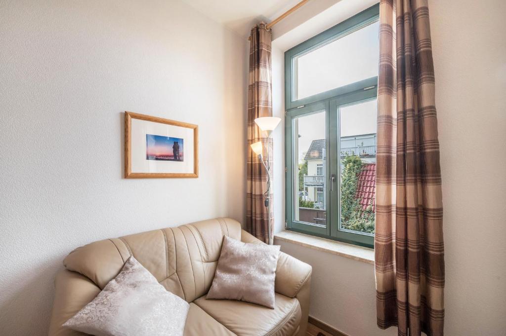 a living room with a chair and a window at Apartment Abendsonne in Kühlungsborn