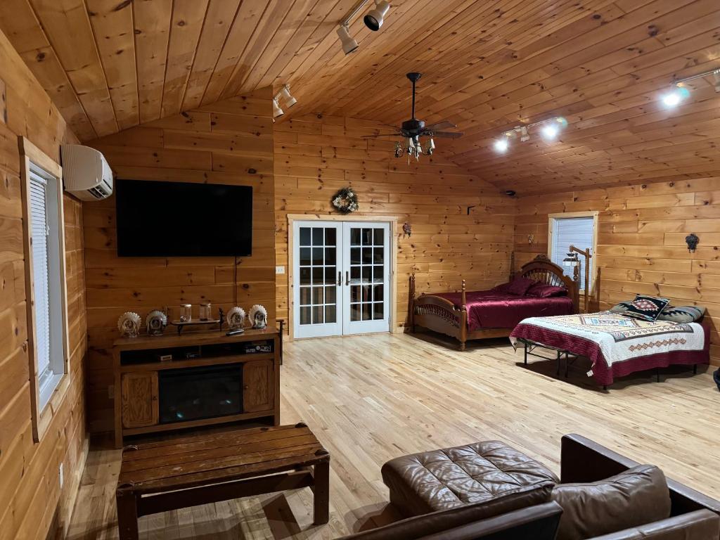 un grand salon avec une télévision et une chambre dans l'établissement The Saloon Cabin Retreat, à Hedgesville