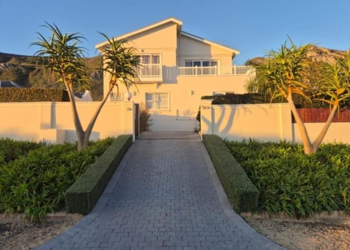 a walkway in front of a house with palm trees at Yellow Wood 1 in Hermanus