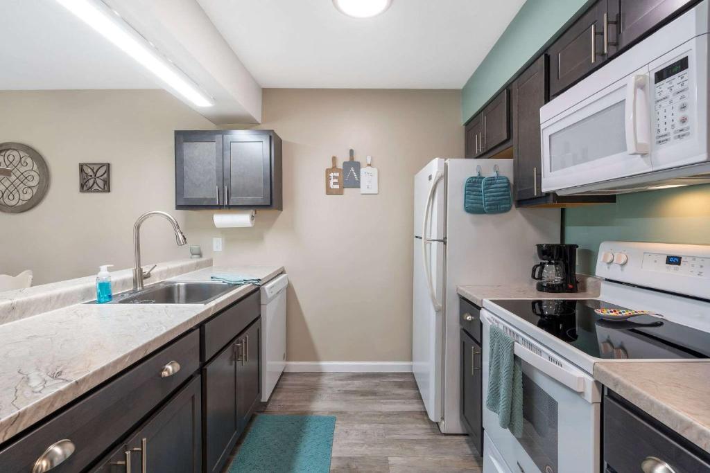 a kitchen with a sink and a refrigerator at Greenside Retreat - Pointe Royale in Branson