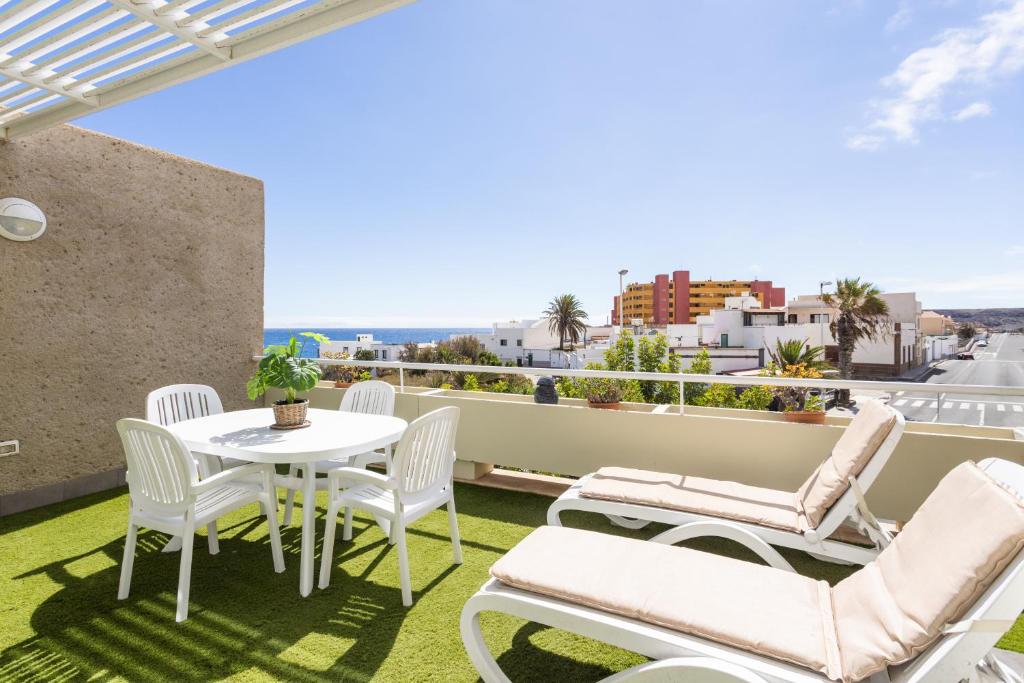 a patio with a table and chairs on a balcony at Eden Rentals Pure Abona in Poris de Abona