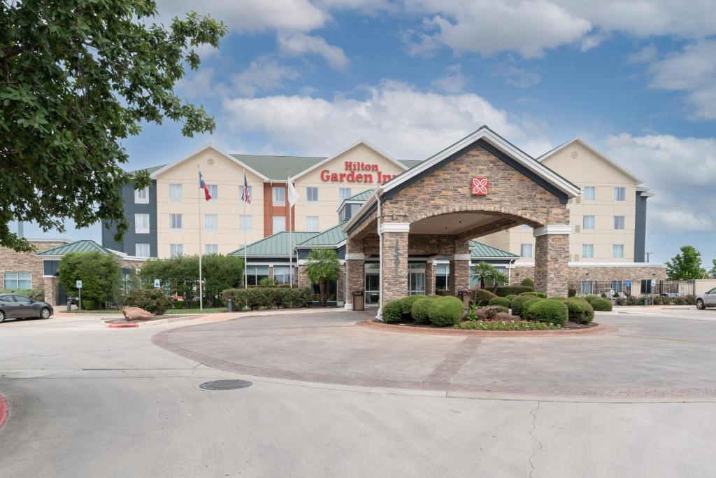 a hotel front of a building with a parking lot at Hilton Garden Inn New Braunfels in New Braunfels