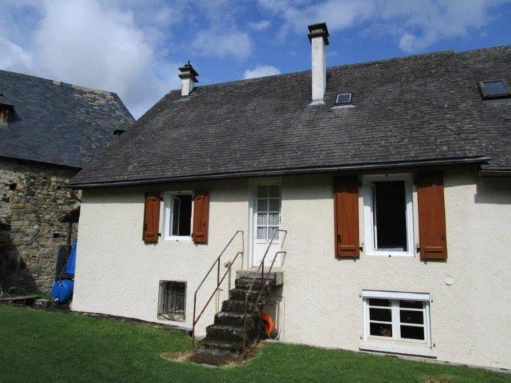 a white house with a black roof and stairs at 113 Val d'Azun - Gîte 6 voyageurs in Arrens-Marsous