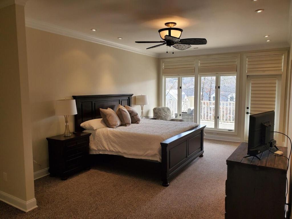 a bedroom with a bed with a ceiling fan and a television at The best of the greenbrier in White Sulphur Springs