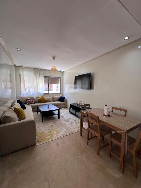 a living room with a couch and a table at Appartement à residence MALAGA BEACH in Mansouria