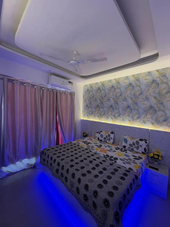 Un dormitorio con una cama negra y luces azules. en elite stay one, en Greater Noida