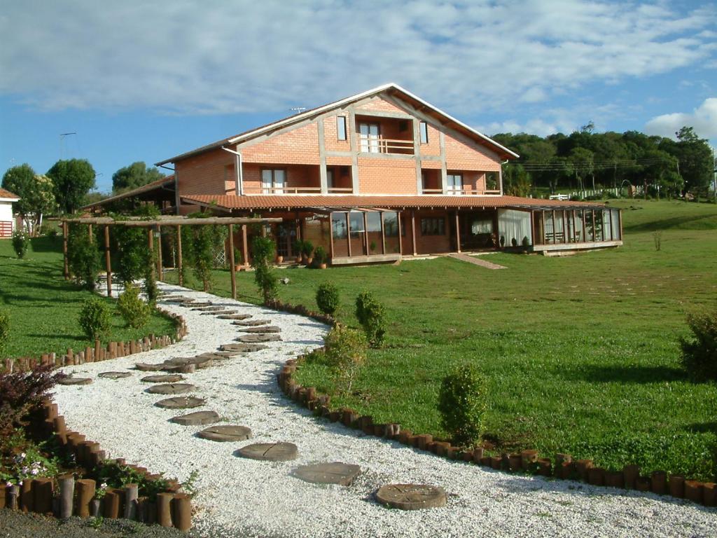a house with a stone path in front of a house at A Cabanha in Caçador
